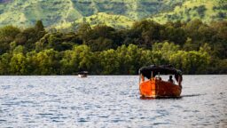 Orange Boat Sailing on the Serene Koyna Lake in Maharashtra